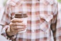 Business man hand holding paper cup of take away drinking coffee  on natural morning sunlight. Royalty Free Stock Photo