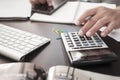 Business man hand holding pen using calculator and documents on office desk with laptop and smart phone ,office, business concept, Royalty Free Stock Photo