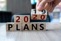 Business man hand holding wooden cube with flip over block 2019 to 2020 Plans word on table background. Resolution, strategy, Royalty Free Stock Photo