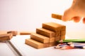 Business man hand put wooden blocks in the shape of a staircase. Royalty Free Stock Photo