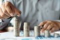 Business man hand putting coin stack for budget Saving money investment and financial accounting management or growing business co Royalty Free Stock Photo