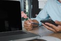 Business man hand using mobile smart phone and credit card  with computer laptop on table.Shop online and make payment Royalty Free Stock Photo