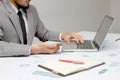 Business man hands busy using cell phone, laptop, pen and notebook at office desk. Analysis the charts and graphs showing the resu Royalty Free Stock Photo