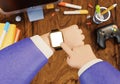 Business man hands using smart watches with desk table, computer and stationary office tools 3D illustration background. Royalty Free Stock Photo