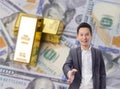 Business man handshake with gold bars and dollar banknote background