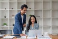 Business man having a discussion with his colleague in an office. Two business people using a laptop in a meeting Royalty Free Stock Photo