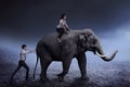 Business man help pushing elephant while his friend sit on it Royalty Free Stock Photo