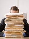 Business man hiding behind tall stack of folders Royalty Free Stock Photo