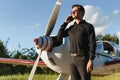 Business man with his airplanes. He is walking in the airport with the smart phone and making a call Royalty Free Stock Photo