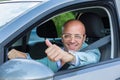 Business man  in his car smiling, showing thumbs up Royalty Free Stock Photo