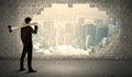 Business man hitting wall with hammer on city view Royalty Free Stock Photo