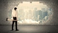 Business man hitting wall with hammer on city view Royalty Free Stock Photo