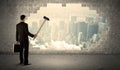 Business man hitting wall with hammer on city view Royalty Free Stock Photo