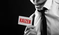 Business man hold a card with text : Kaizen