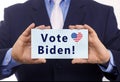 Business man hold paper vote Biden text on it