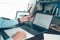 Business man hold stylus pen and pointing to laptop at office  with document report, graph, financial report on screen Royalty Free Stock Photo