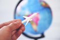 Business man holding airliner aircraft plane on world globe background - worldwide travel concept