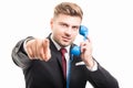 Business man holding blue telephone receiver pointing camera Royalty Free Stock Photo