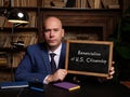 Business man holding chalkboard with written text Renunciation of U.S. Citizenship - closeup shot Royalty Free Stock Photo