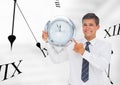 Business man holding a clock against background with clocks Royalty Free Stock Photo