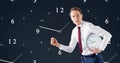 Business man holding a clock against background with clocks Royalty Free Stock Photo
