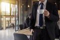 Business man holding coffee cup and looking away while standing outdoors with coffee shop Royalty Free Stock Photo