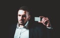 Business man holding credit card. Business card. Portrait of a businessman on black background. Man looking at camera Royalty Free Stock Photo