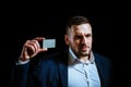 Business man holding credit card. Business card. Portrait of a businessman on black background. Man looking at camera Royalty Free Stock Photo