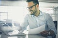 Business man holding document and checking e mail on laptop. Royalty Free Stock Photo