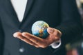 Business man holding earth globe model in hand and - Business global and travel around the world or save the world concept Royalty Free Stock Photo