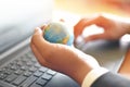 Business man holding earth globe model in hand and use a laptop - Business technology global and around the world concept Royalty Free Stock Photo