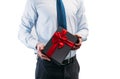 Business man holding a gift with a red ribbon. Guy on a white background in a light shirt with a tie. Black gift box Royalty Free Stock Photo