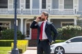 Business man holding mobile cell phone using app texting sms message wearing suit. Young urban professional man using Royalty Free Stock Photo