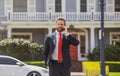 Business man holding mobile cell phone using app texting sms message wearing suit. Young urban professional man using Royalty Free Stock Photo