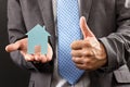 Business man holding a model of a house in his hand Royalty Free Stock Photo