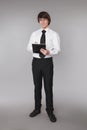 Business man holding notebook. Confident handsome student smiling at camera, isolated on studio rey background. People and office Royalty Free Stock Photo