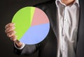 Business man holding a pie chart made from cardboard paper.