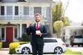 Business man holding piggy bank on home house background. Handsome caucasian man holding piggybank for money for savings Royalty Free Stock Photo