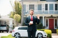 Business man holding piggy bank on home house background. Handsome caucasian man holding piggybank for money for savings Royalty Free Stock Photo