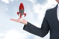 Business man holding a rocket against the sky Royalty Free Stock Photo