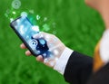 Business man holding smart phone with media icons Royalty Free Stock Photo