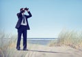 Business Man Holding Spyglass on Beach