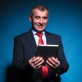 Business man holding a tablet pad and smiles Royalty Free Stock Photo