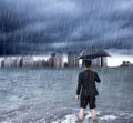 Business man holding an umbrella and standing with cloudburst