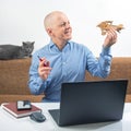 Business man at home office dreaming about his achievement. Business dream concept. A man holds a wooden airplane model in his Royalty Free Stock Photo