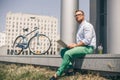 Business man with laptop and sport bike sitting in city. Royalty Free Stock Photo