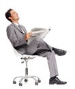 Business man, laughing and reading newspaper in studio, headlines and information on current events. Businessperson