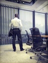 Business man looking on city through an office window