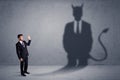 Business man looking at his own devil demon shadow concept Royalty Free Stock Photo