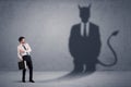 Business man looking at his own devil demon shadow concept Royalty Free Stock Photo